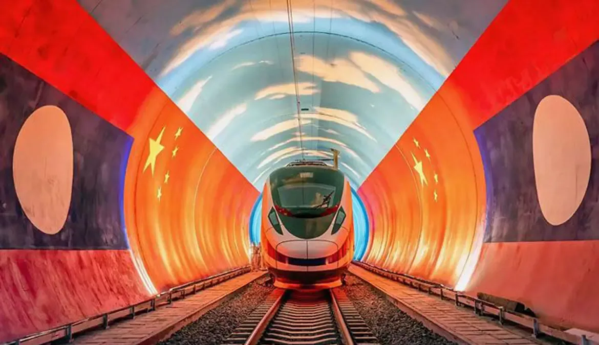 A high-speed train emerging from a tunnel portal painted with the Lao and Chinese flags