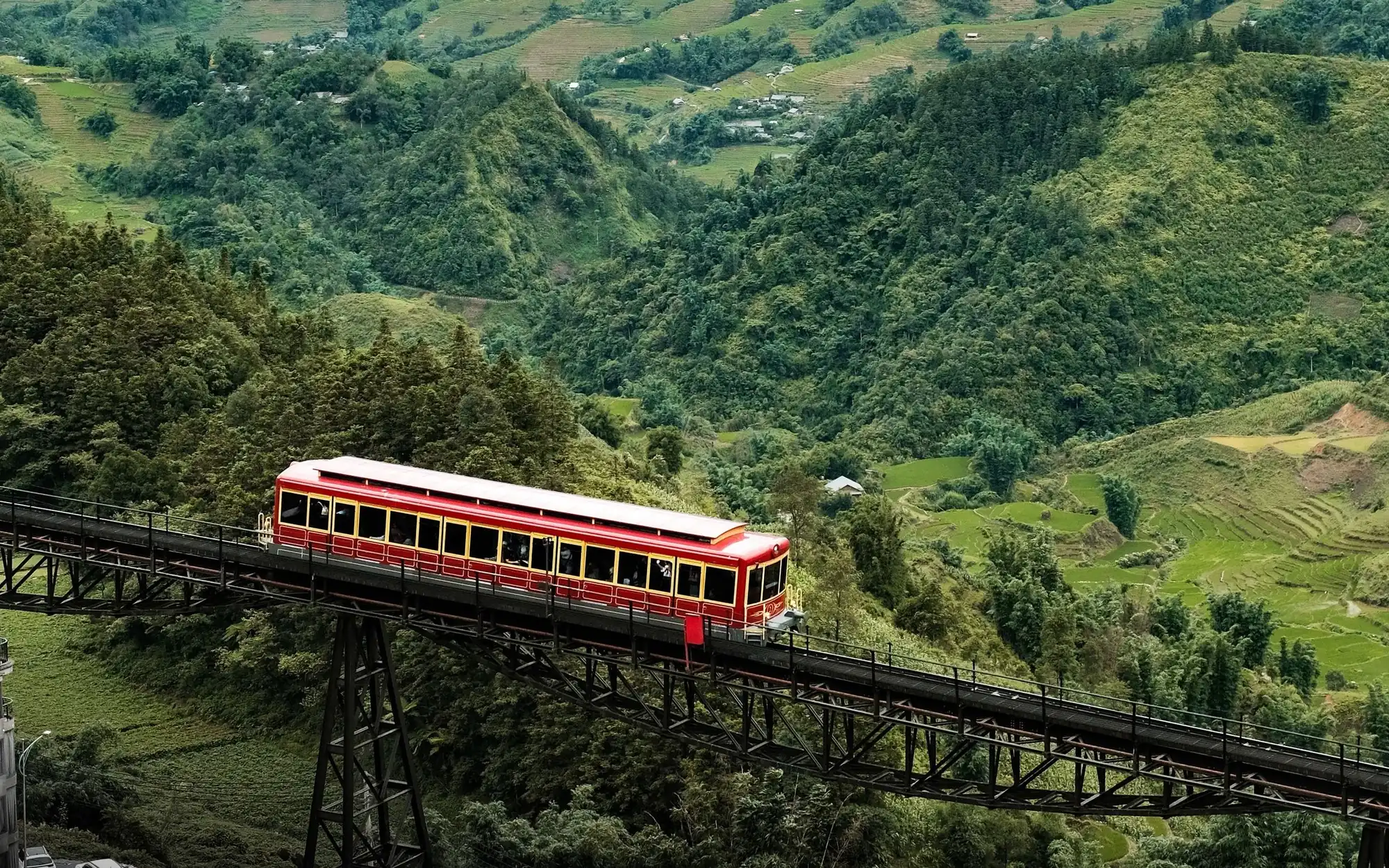 越南北部老街山區，一列紅色火車駛過高架橋