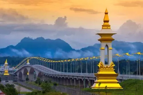 Puente de la Amistad sobre el Mekong al atardecer, visto desde la orilla laosiana