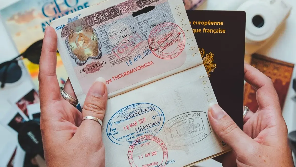 A Lao visa sticker and immigration stamps across an open passport