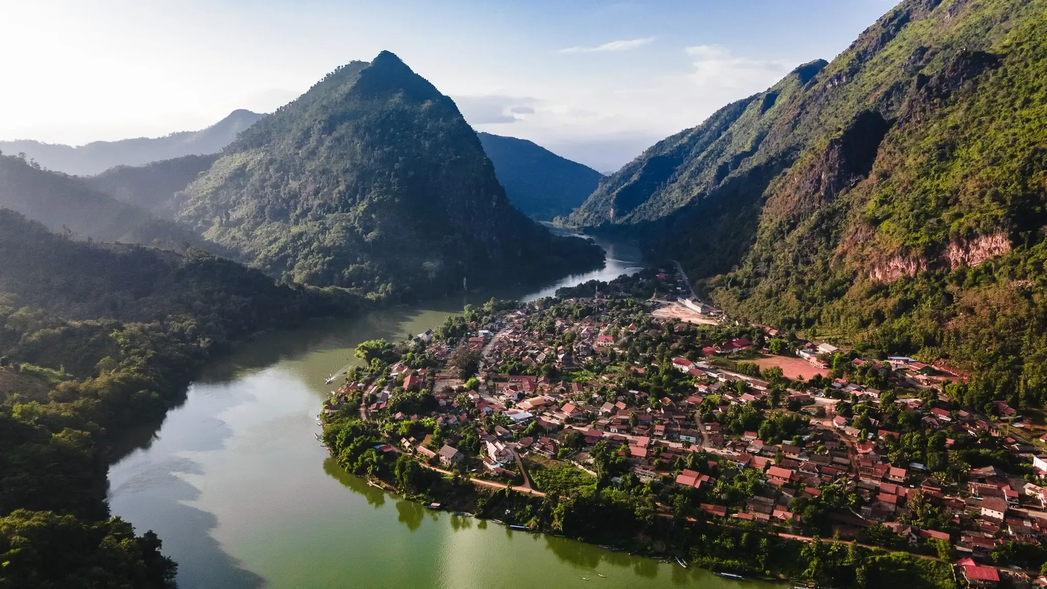 Nong Khiaw at a bend in the Nam Ou river, surrounded by limestone peaks, seen from above